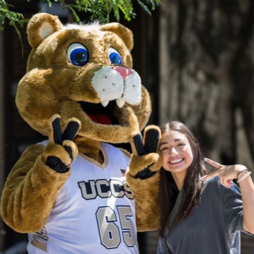 student posing with clyde at orientation