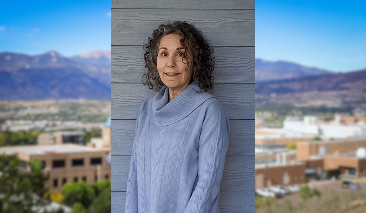 headshot of professor Ginsberg over a blurry image of UCCS campus